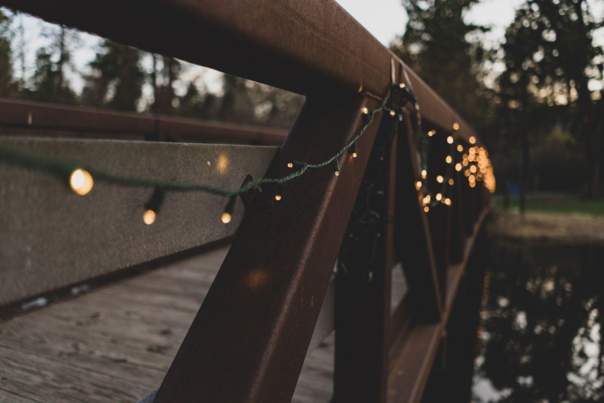 wooden bridge with warm white led light string strung on rail